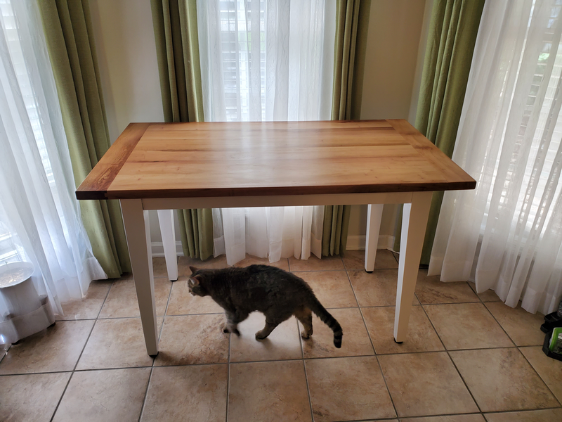 Completed dining table in the dining nook with a thoughouly unimpressed old cat walking underneath on the way to her water dish