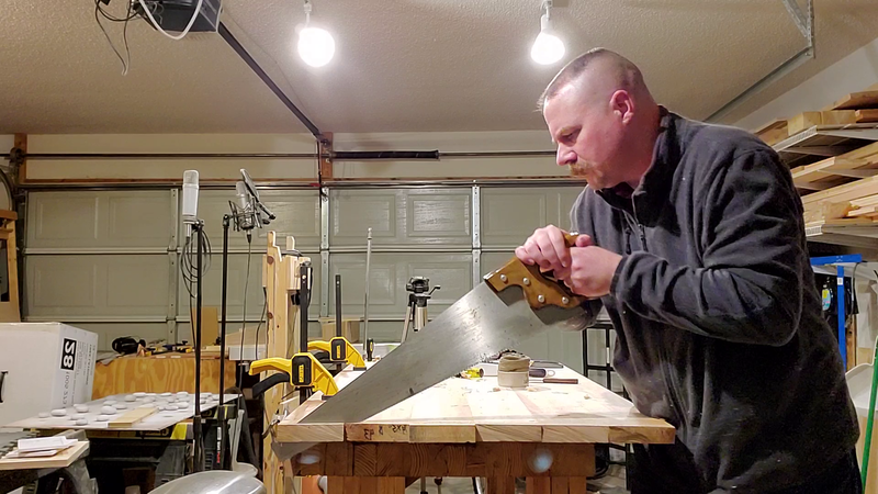 Me crosscutting the table top with a Disston saw 